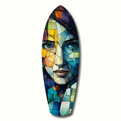 Stained glass style wall art depicting a woman's face in colorful geometric segments of blue, yellow, orange, and green on an elongated oval surfboard shape.