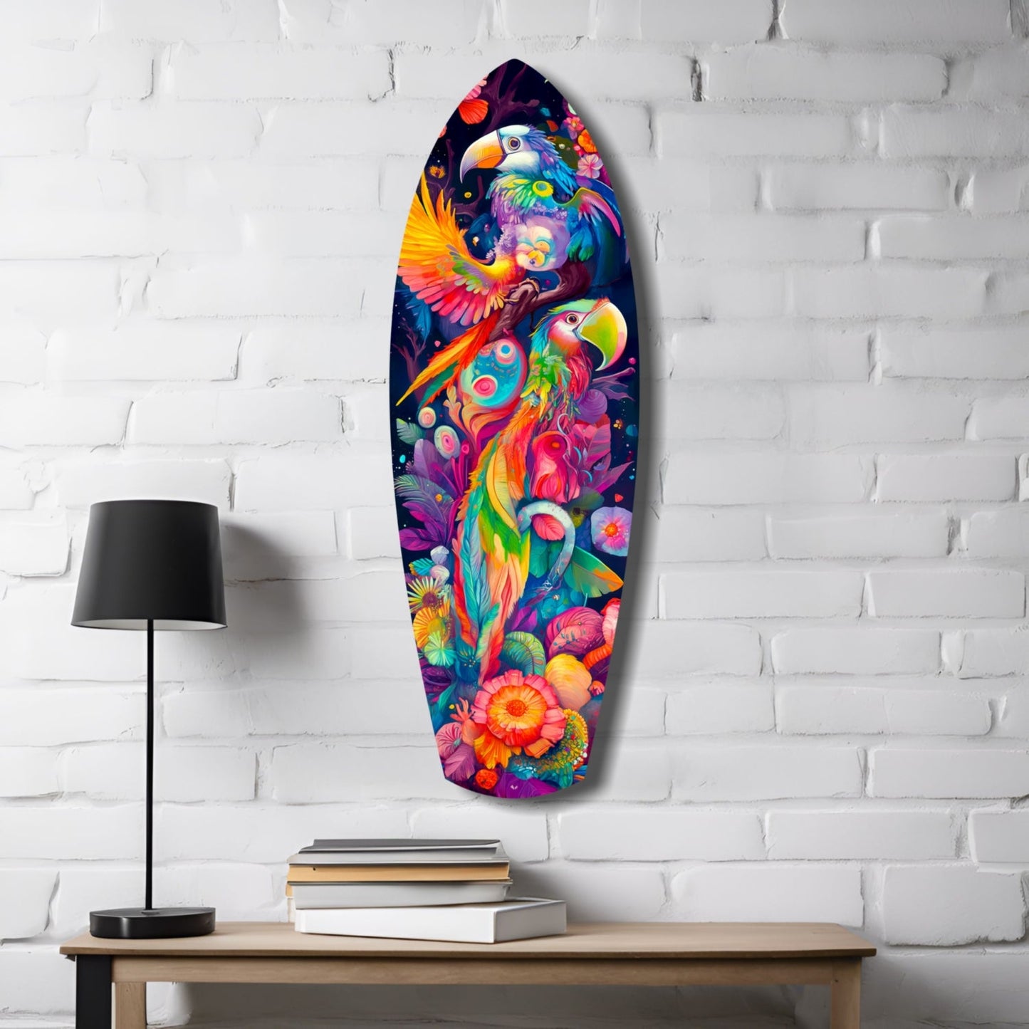 Colorful glass surfboard wall art featuring vibrant tropical birds and flowers displayed on white brick wall next to wooden desk with lamp and books.