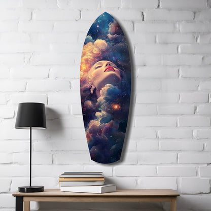 Celestial Dreamer glass wall art mounted on white brick above wooden table with black lamp and stacked books, featuring woman's face surrounded by cosmic clouds and stars.