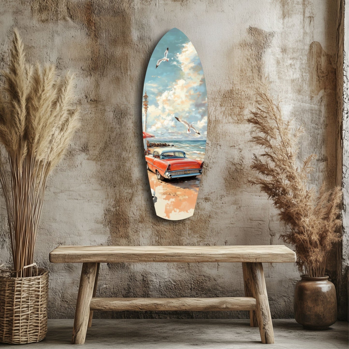 Surfboard-shaped glass wall art depicting a red vintage car on a beach with lighthouse and seagulls, displayed above a wooden bench against a textured grey wall.