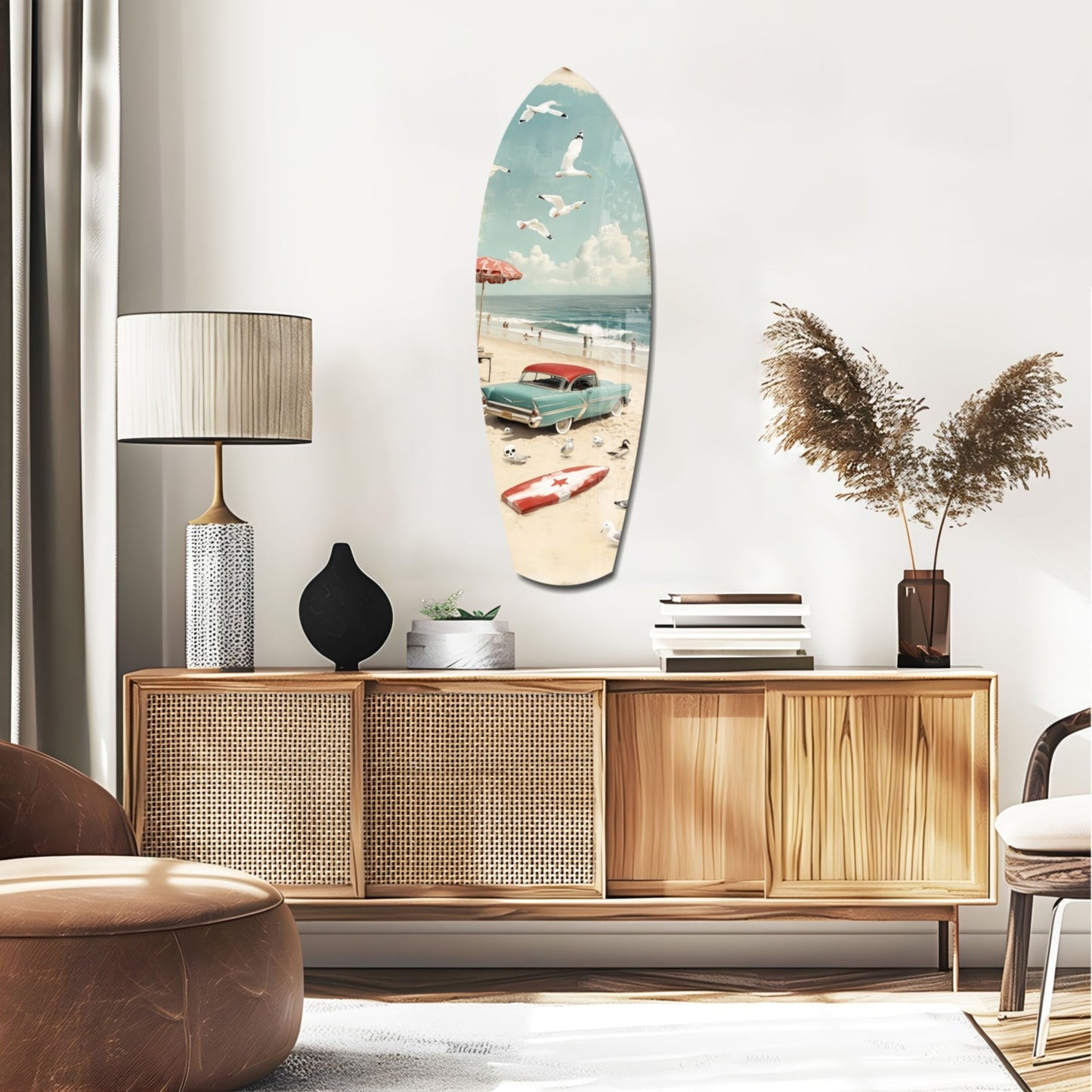 Surfboard-shaped glass wall art depicting a vintage beach scene with turquoise car, umbrella, and sailboat hung above a wooden credenza.