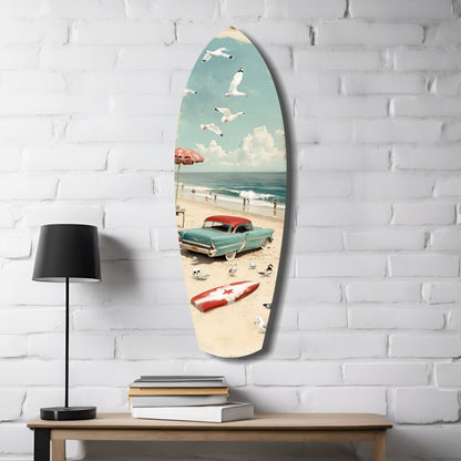 Surfboard-shaped glass wall art displaying vintage beach scene with turquoise car, umbrella, and seagulls mounted on white brick wall above wooden table with lamp and books.