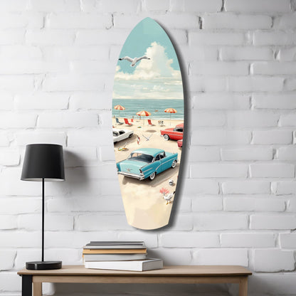 Surfboard-shaped glass wall art displaying a retro beach scene with turquoise sky, vintage cars, and umbrellas, mounted on white brick.