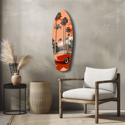 Orange surfboard-shaped glass wall art featuring a red vintage car and palm trees, displayed above a wooden chair in a minimalist interior.