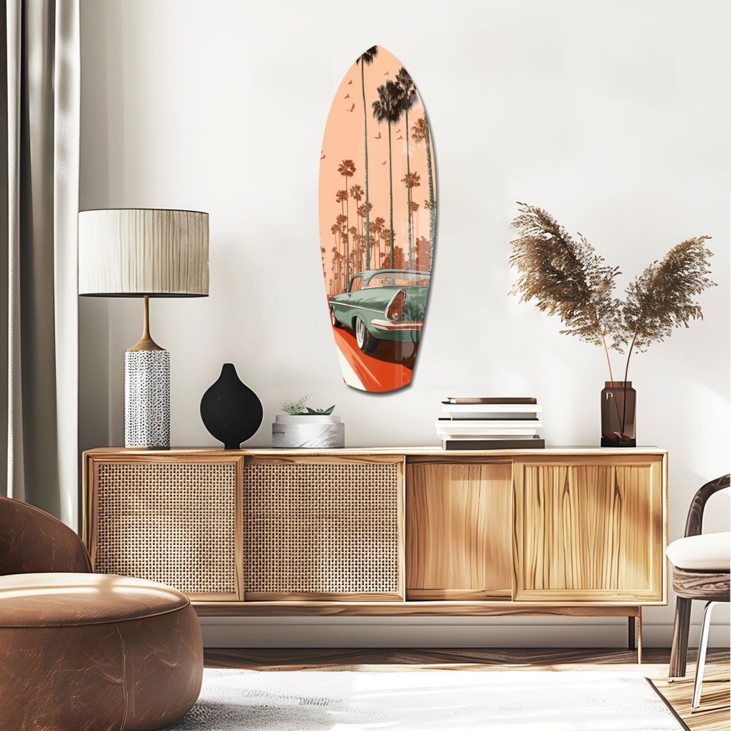 Surfboard-shaped glass art with vintage car and palm trees in peach and teal tones, displayed above mid-century wooden credenza.