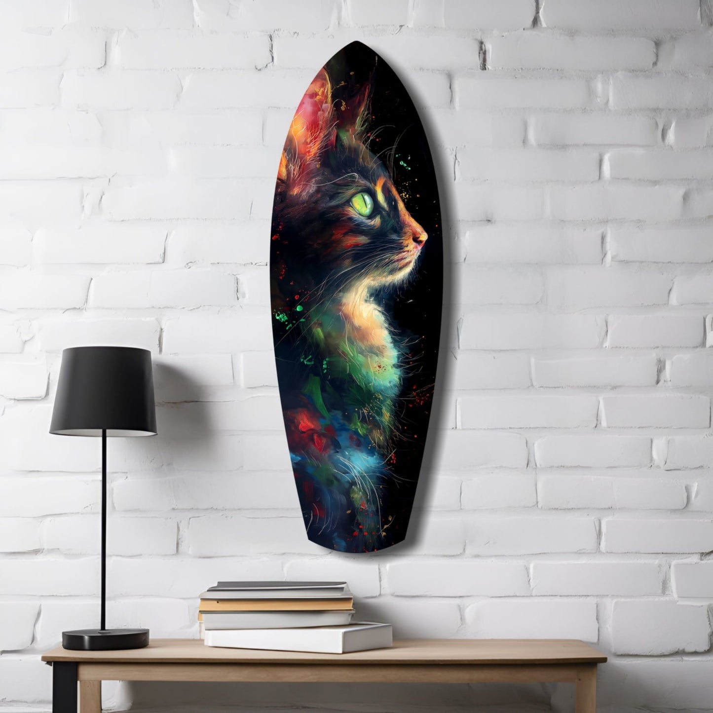 Oval glass wall art depicting a colorful cat with glowing green eyes and vibrant red, orange, blue, and green accents displayed above a wooden desk with lamp and books.