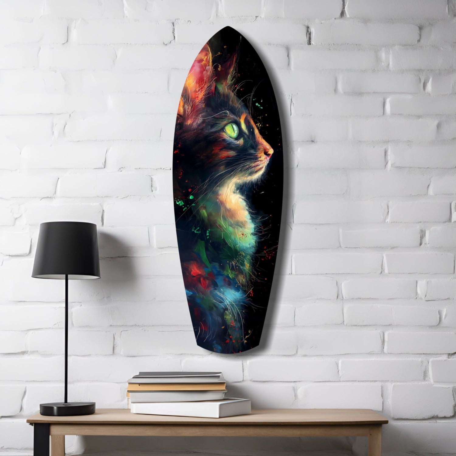 Oval glass wall art depicting a colorful cat with glowing green eyes and vibrant red, orange, blue, and green accents displayed above a wooden desk with lamp and books.