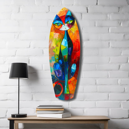 Colorful cubic cat glass wall art with vibrant geometric sections displayed on white brick wall above wooden desk with lamp and books.