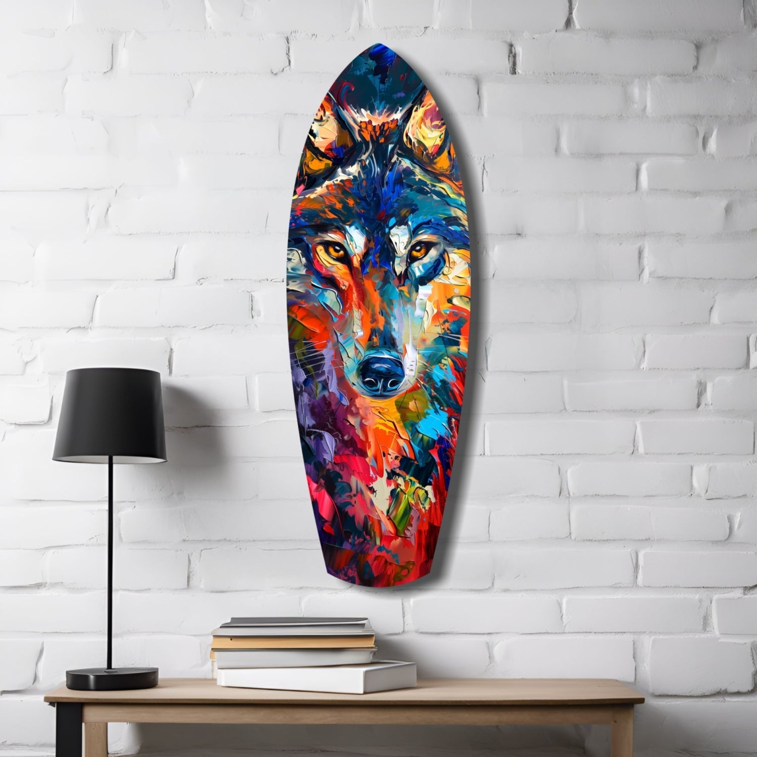 Colorful glass surfboard wall art depicting a multicolored wolf's face displayed on white brick with lamp and books below.