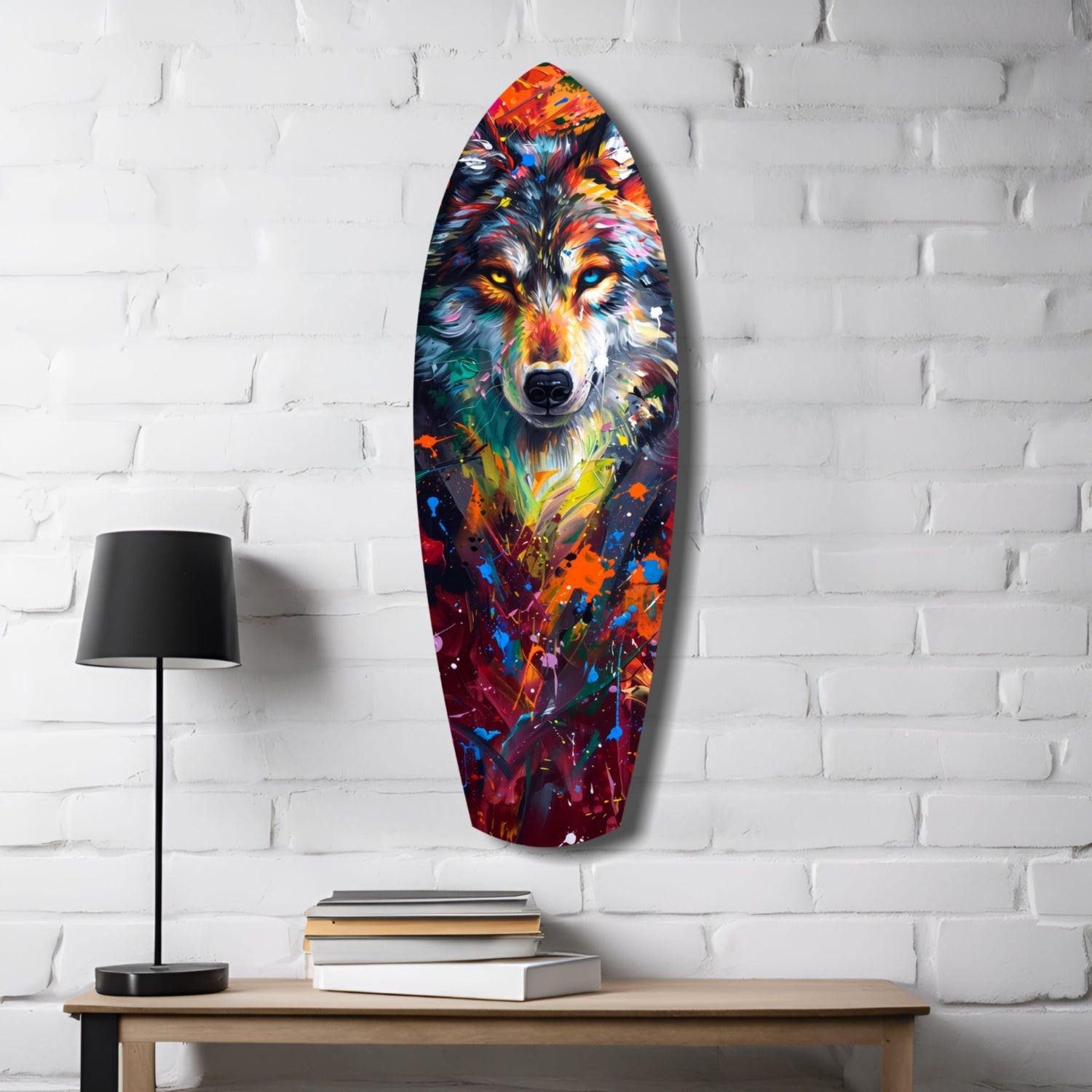 Colorful wolf head glass art mounted on white brick wall above wooden desk with lamp and stacked books.