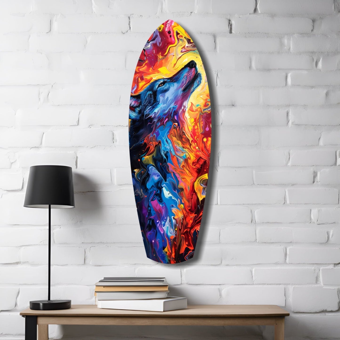 Vibrant abstract glass surfboard art hanging on white brick wall beside wooden table with lamp and books.