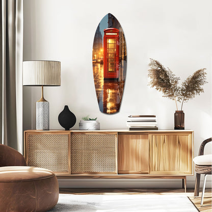 Oval glass wall art depicting an illuminated red London telephone booth displayed above a wooden credenza in a modern living room setting.