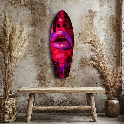 Neon pink and purple lips glass wall art displayed above wooden bench against textured concrete wall with dried grasses.