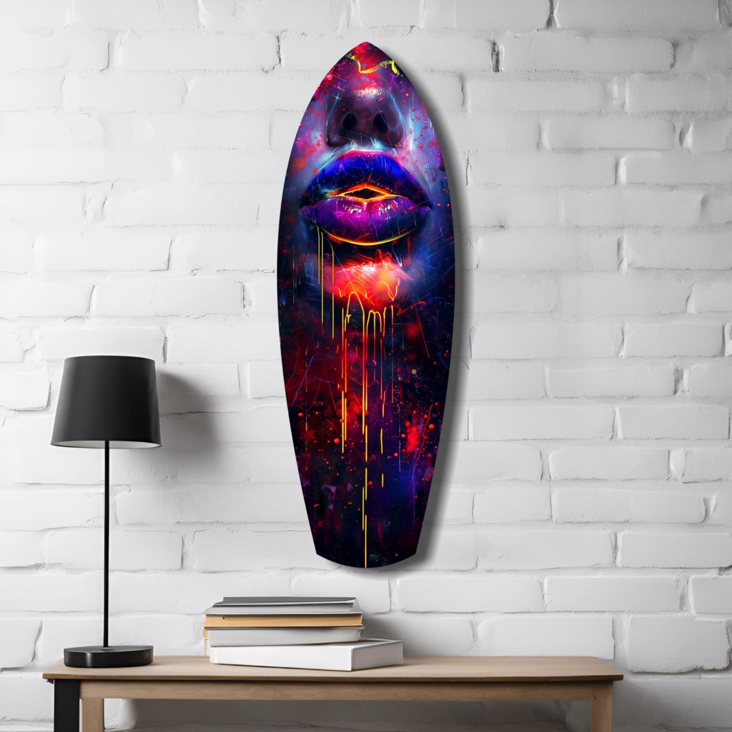 Colorful Lips V10 glass wall art mounted above wooden desk with lamp and stacked books, featuring vibrant neon pink, blue, and red glowing lips design on white brick wall.