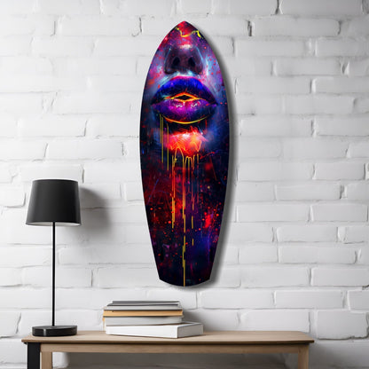 Colorful Lips V10 glass wall art mounted above wooden desk with lamp and stacked books, featuring vibrant neon pink, blue, and red glowing lips design on white brick wall.