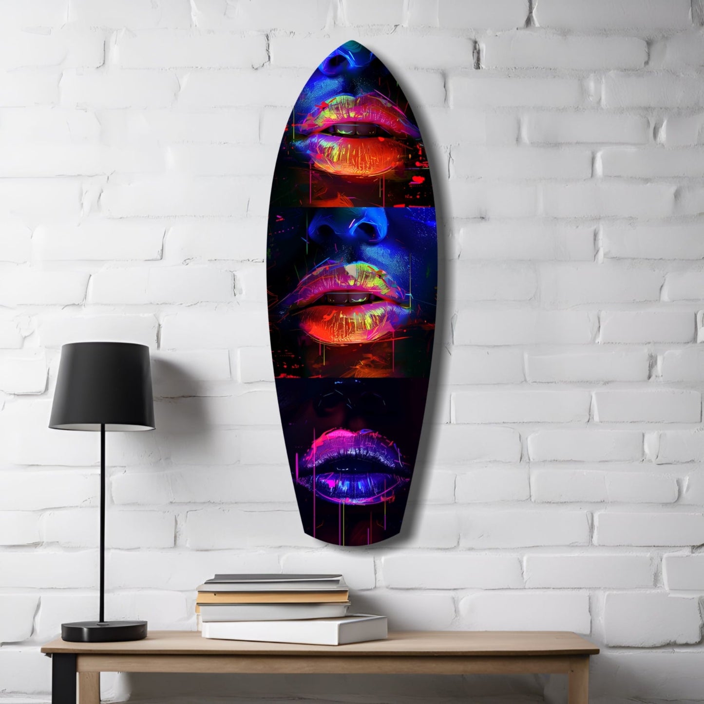 Neon lips glass wall art in vibrant red, blue, and pink displayed on white brick wall above wooden desk with lamp and books.