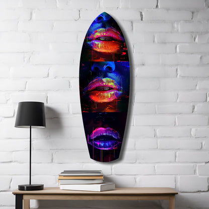 Neon lips glass wall art in vibrant red, blue, and pink displayed on white brick wall above wooden desk with lamp and books.