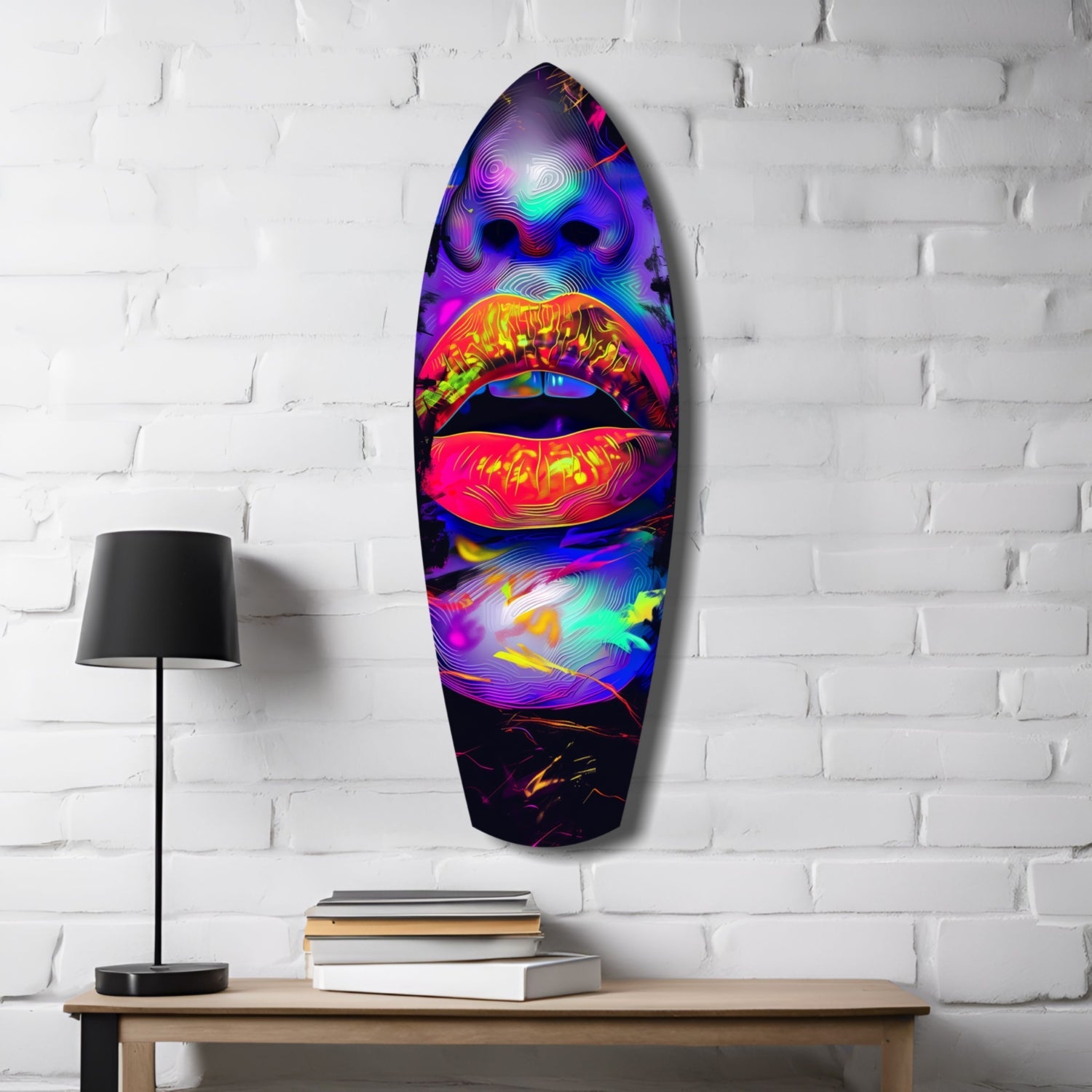 Neon lips glass wall art in vibrant purple, pink, and cyan displayed above wooden table with lamp and books.