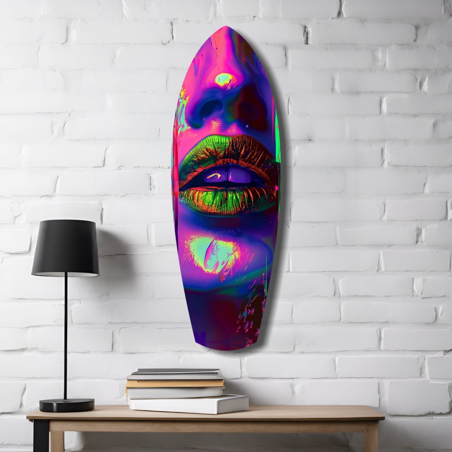 Vibrant neon lips glass wall art mounted on white brick above wooden desk with lamp and books.