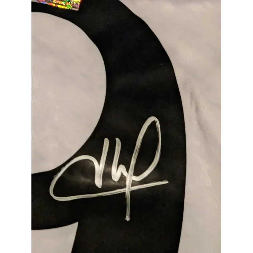 Black fabric with white handwritten signature and holographic sticker on Kylian Mbappe Real Madrid jersey
