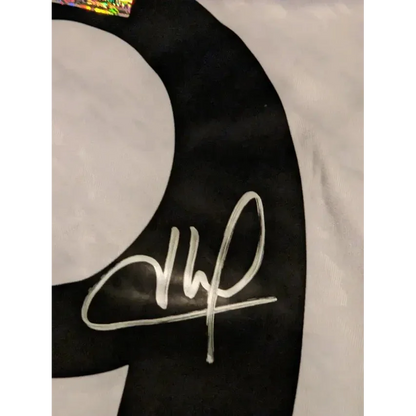 Black fabric with white handwritten signature and holographic sticker on Kylian Mbappe Real Madrid jersey