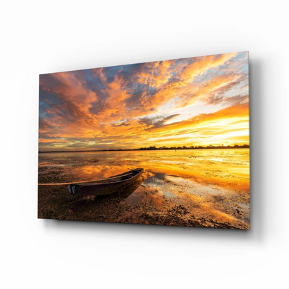 Vibrant sunset over water with rowboat in stunning sunset boat glass wall art