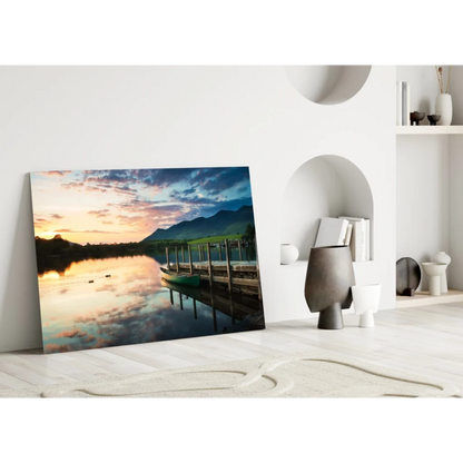 Vibrant sunset glass wall art with dock, canoe, lake, and mountains
