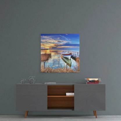 Serene lakeside sunset with white boat on dock, glass wall art