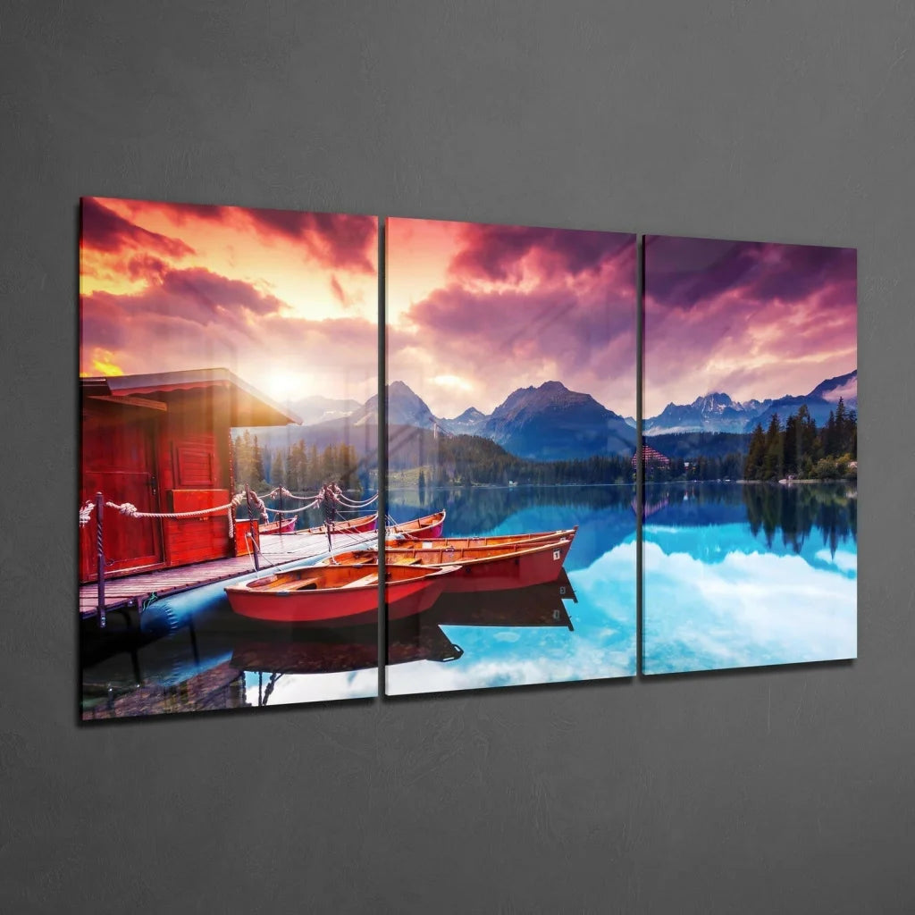 Stunning lakeside sunset glass wall art with red boats triptych