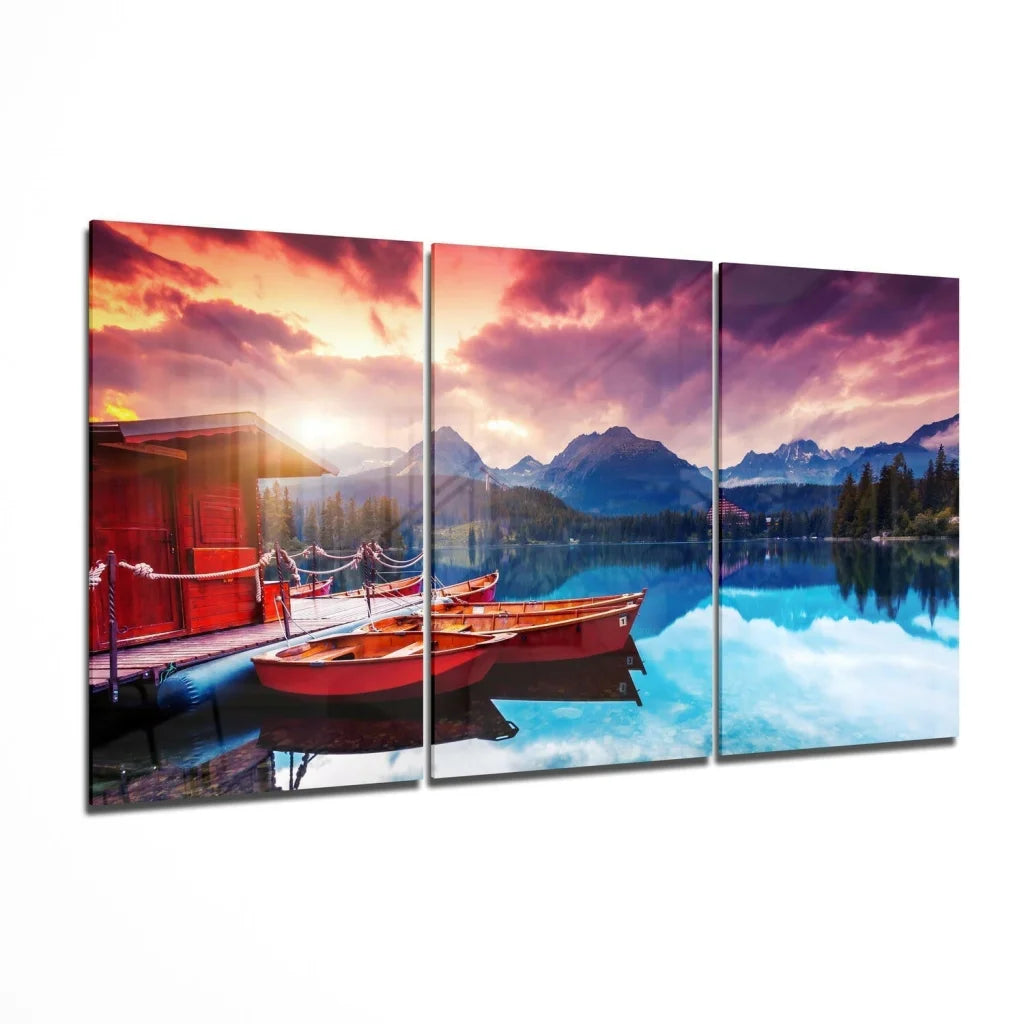 Stunning lakeside sunset glass wall art with red boats triptych