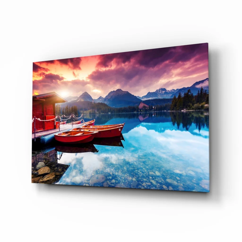 Vibrant sunset lake glass wall art with red boats and mountain reflections