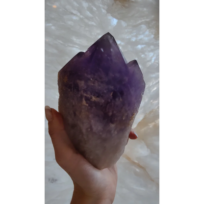 Hand holding large Bolivian amethyst point from Anahi Mine