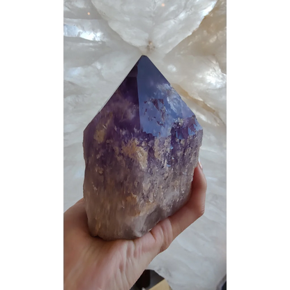 Hand holding large Bolivian amethyst point from Anahi Mine with deep purple hues
