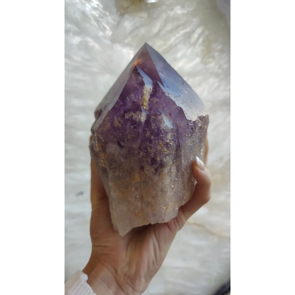 Hand holding large Bolivian amethyst point from Anahi Mine