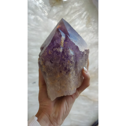 Hand holding large Bolivian amethyst point from Anahi Mine