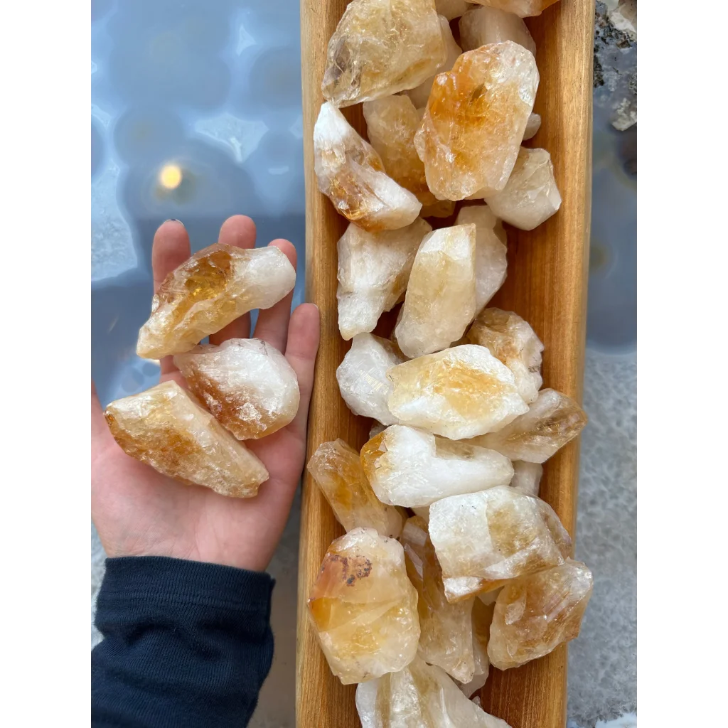 Hand holding large citrine raw crystals from Brazil, golden yellow