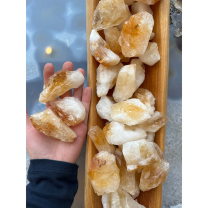 Hand holding large citrine raw crystals from Brazil, golden yellow