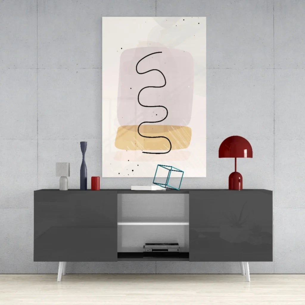 Soft pink mustard yellow abstract glass wall art with black wave on gray table