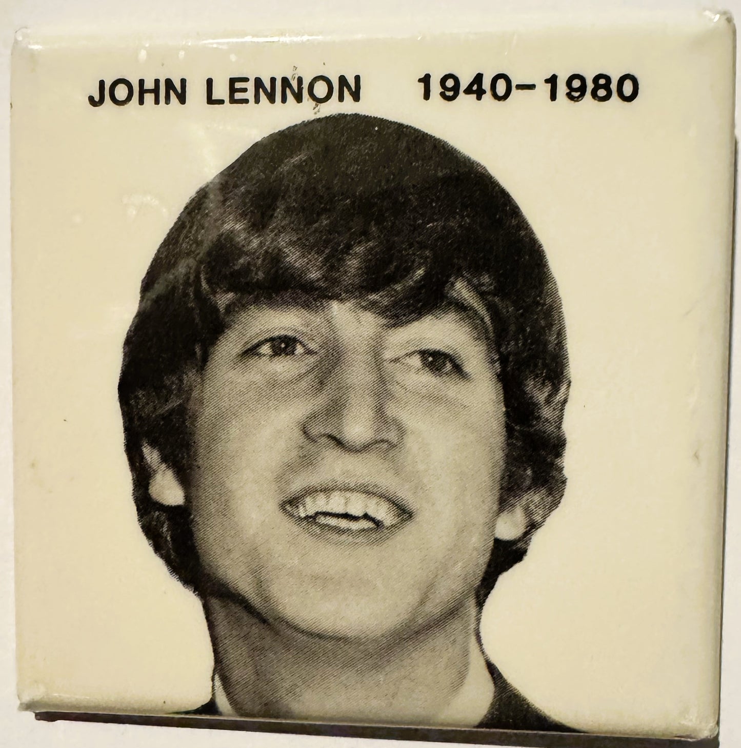 Black and white portrait photograph of John Lennon with text "JOHN LENNON 1940-1980" on cream background.