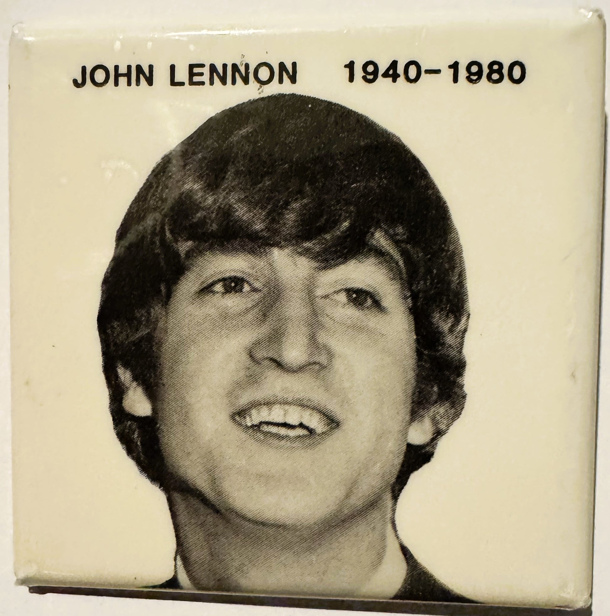 Black and white portrait photograph of John Lennon with text "JOHN LENNON 1940-1980" on cream background.