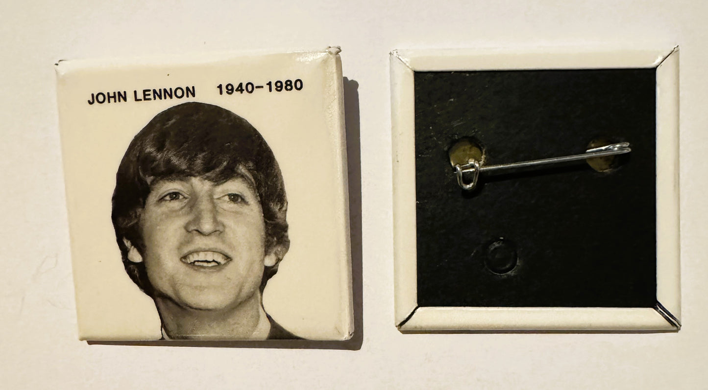 Cream-colored square pin with John Lennon portrait and "1940-1980" text; reverse shows metal clasp.