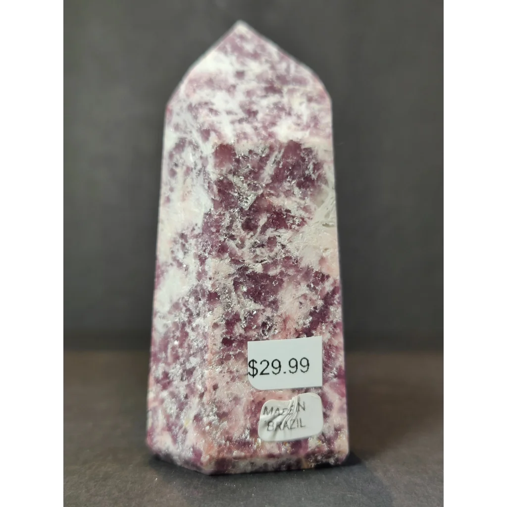 A lepidolite polished obelisk tower sculpture with a pointed shape and mottled deep pink and white hues