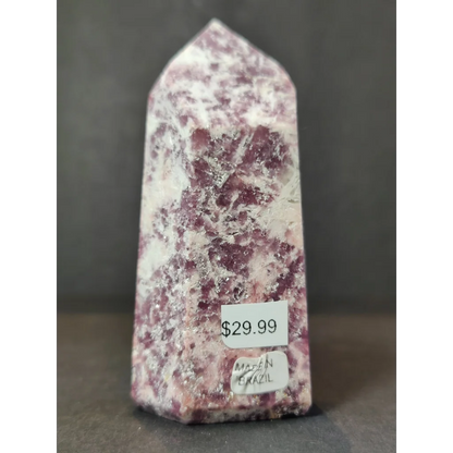 A lepidolite polished obelisk tower sculpture with a pointed shape and mottled deep pink and white hues