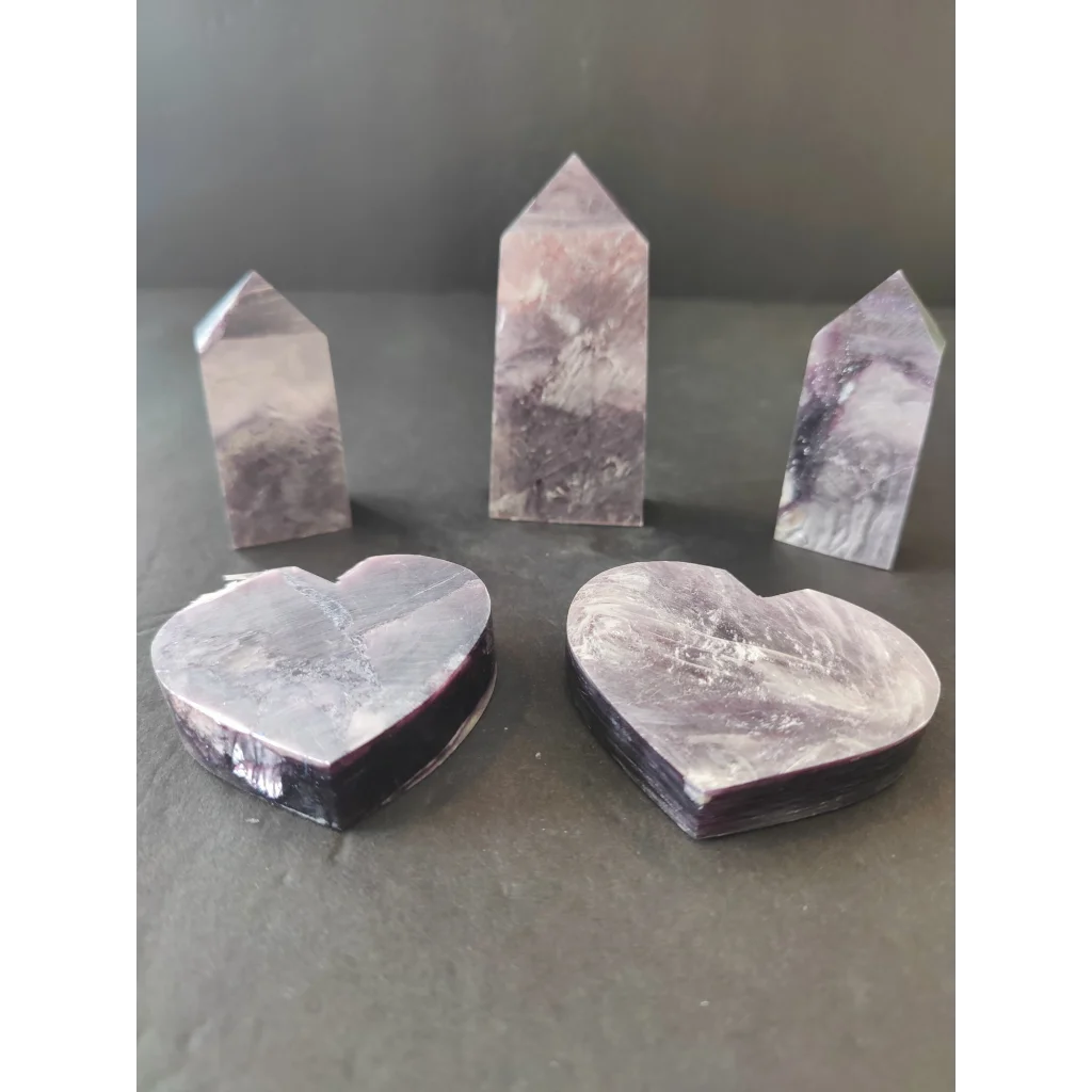 Set of three polished purple and white lepidolite marble obelisks with two heart-shaped bases and smooth reflective surfaces