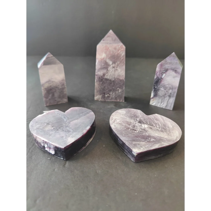 Set of three polished purple and white lepidolite marble obelisks with two heart-shaped bases and smooth reflective surfaces