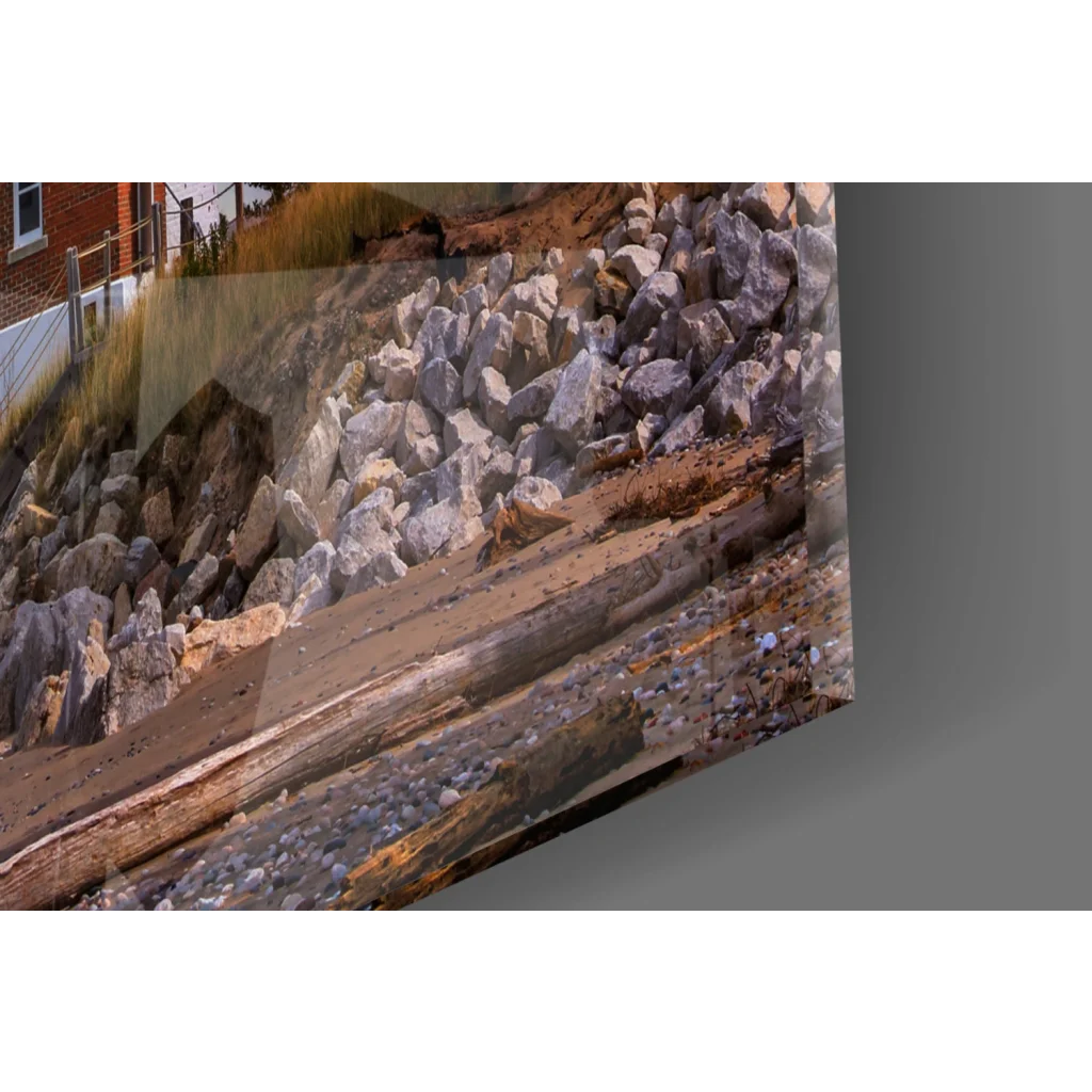 Rugged coastal glass wall art print of rocks and driftwood sunset