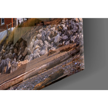 Rugged coastal glass wall art print of rocks and driftwood sunset