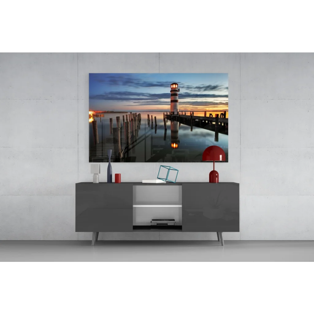 Modern red lamp on gray console with lighthouse sunset glass wall art