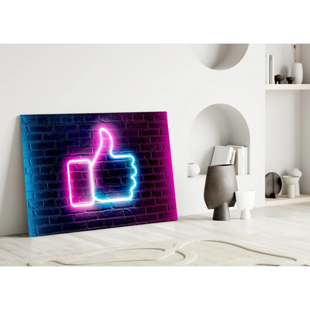 Vibrant neon pink and blue thumbs-up glass wall art on dark brick canvas