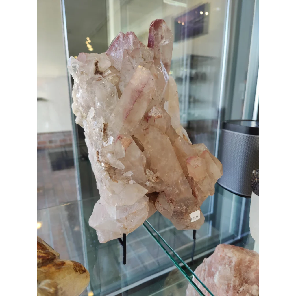 Lithium quartz cluster weighing 7.55kg featuring translucent pink and clear quartz cluster with jagged faceted edges on stand
